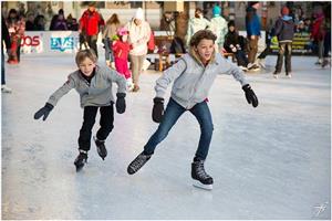 Two boys ice skating in public